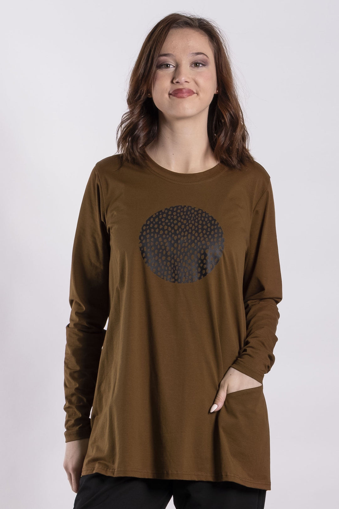 Person wearing a brown long-sleeve Deaane Hobbs tee shirt with a graphic design and black pants on a white background