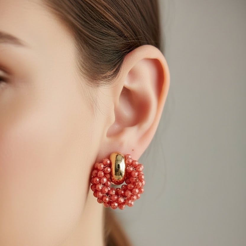 Pair of red beaded earrings on a light gray background