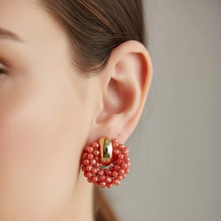 Pair of red beaded earrings on a light gray background