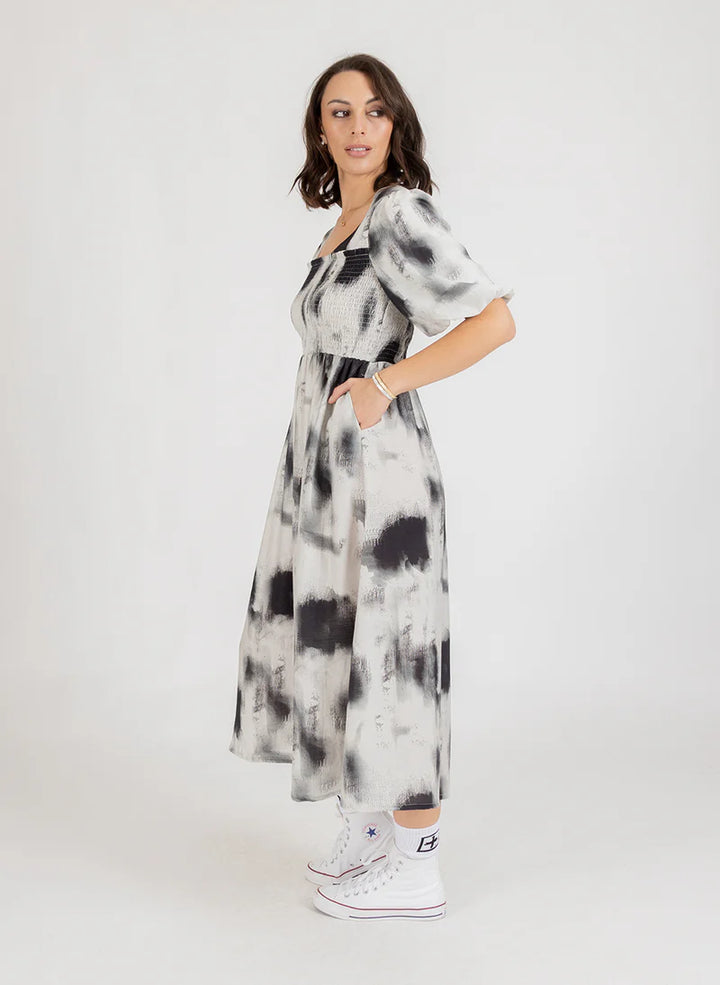 Woman wearing a black and white tie-dye dress on a white background