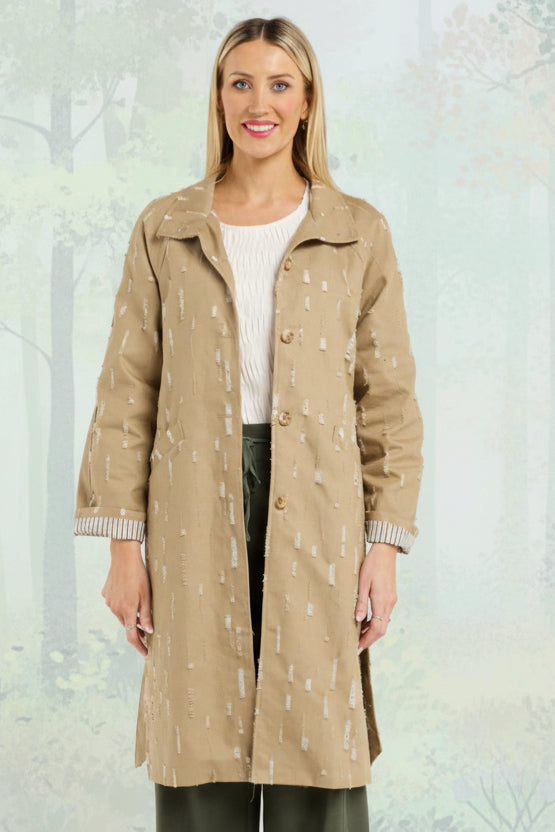 Woman wearing a beige trench coat on a white background