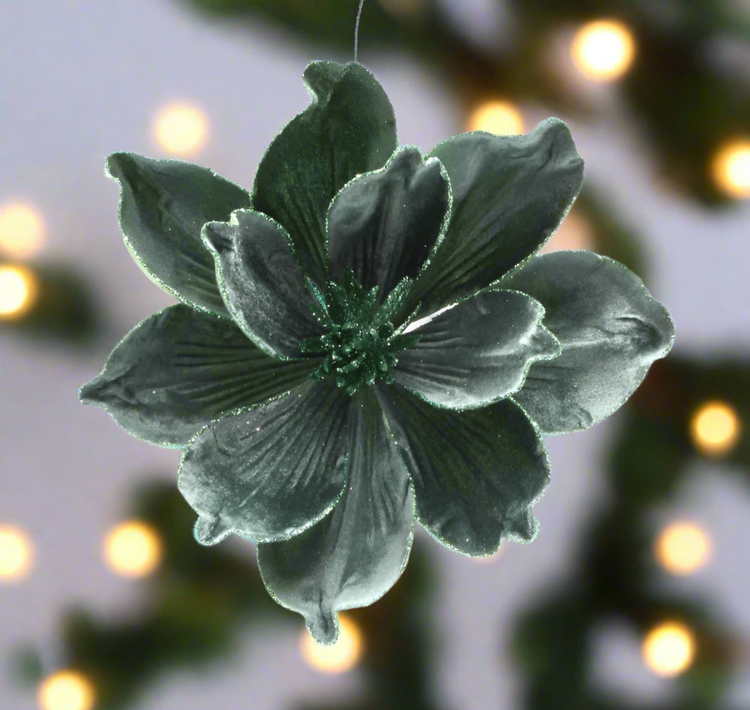 Dark green flower-like brooch on a white background