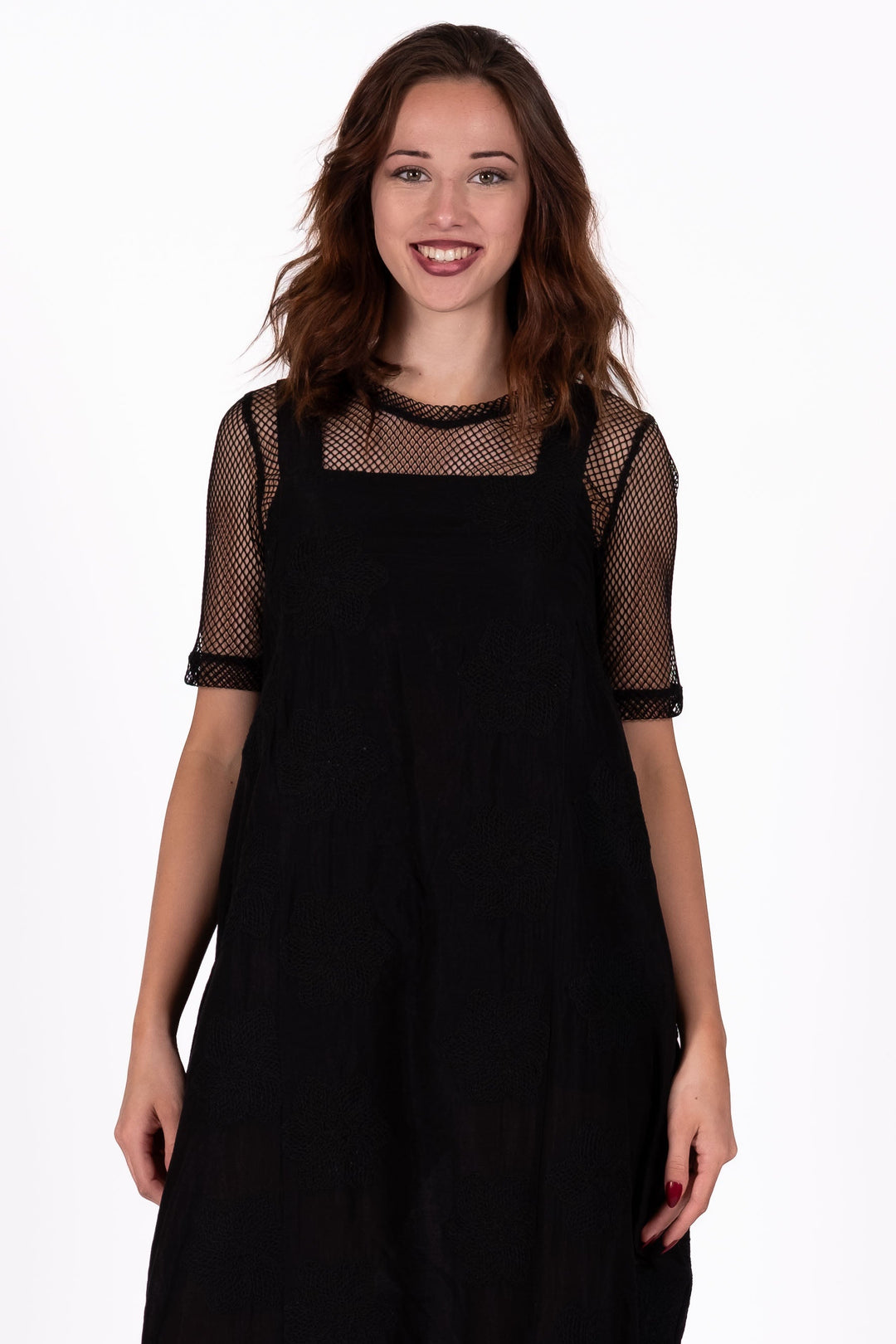 Woman wearing a black dress AND FISHNET TEE UNDERNEATH on a white background