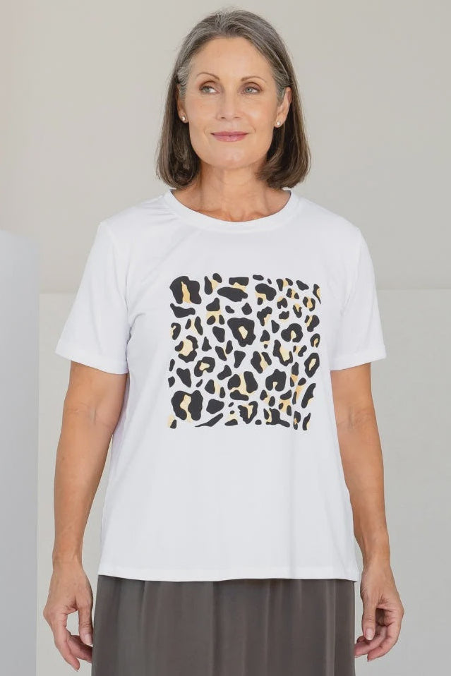 Woman wearing a white t-shirt with a leopard print design on a plain background