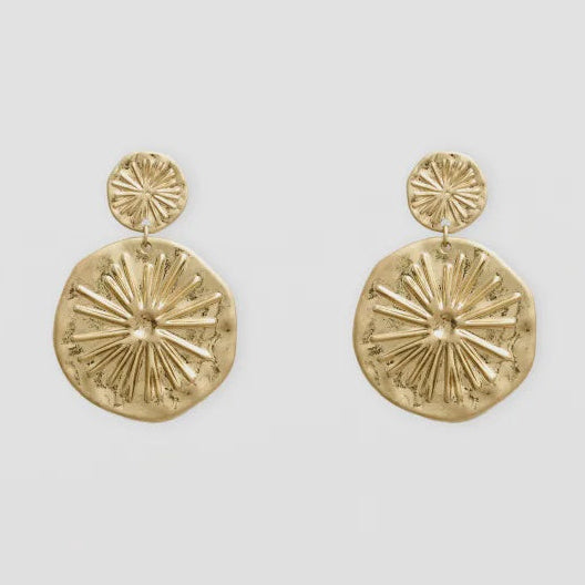 Gold circular earrings on a light gray background