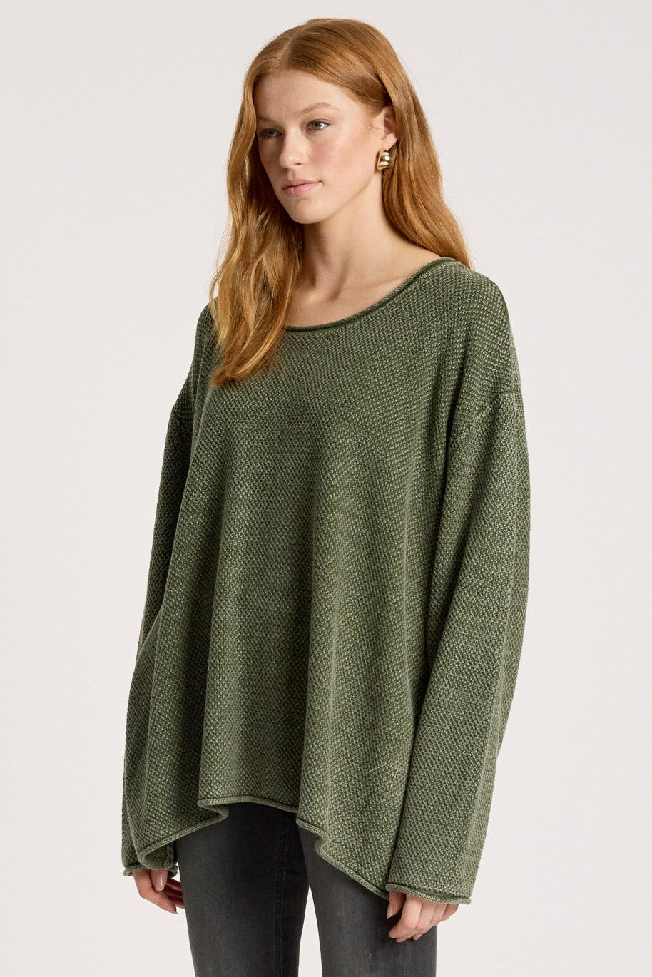 Woman wearing a green sweater and black pants on a white background