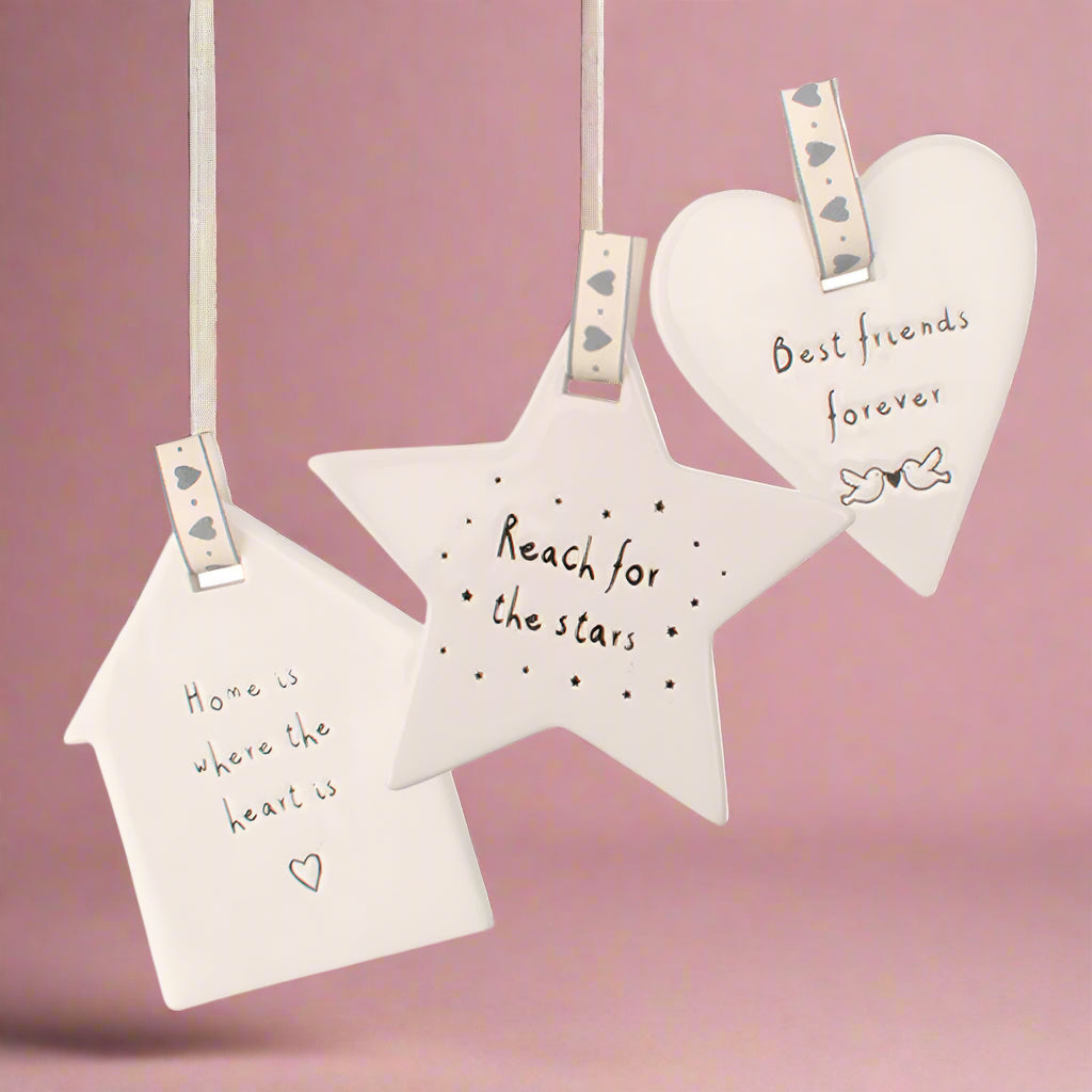 Decorative wall hangings with motivational phrases on a white background