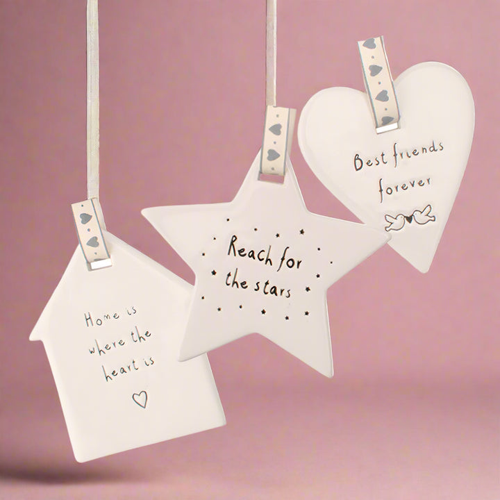 Decorative wall hangings with motivational phrases on a white background