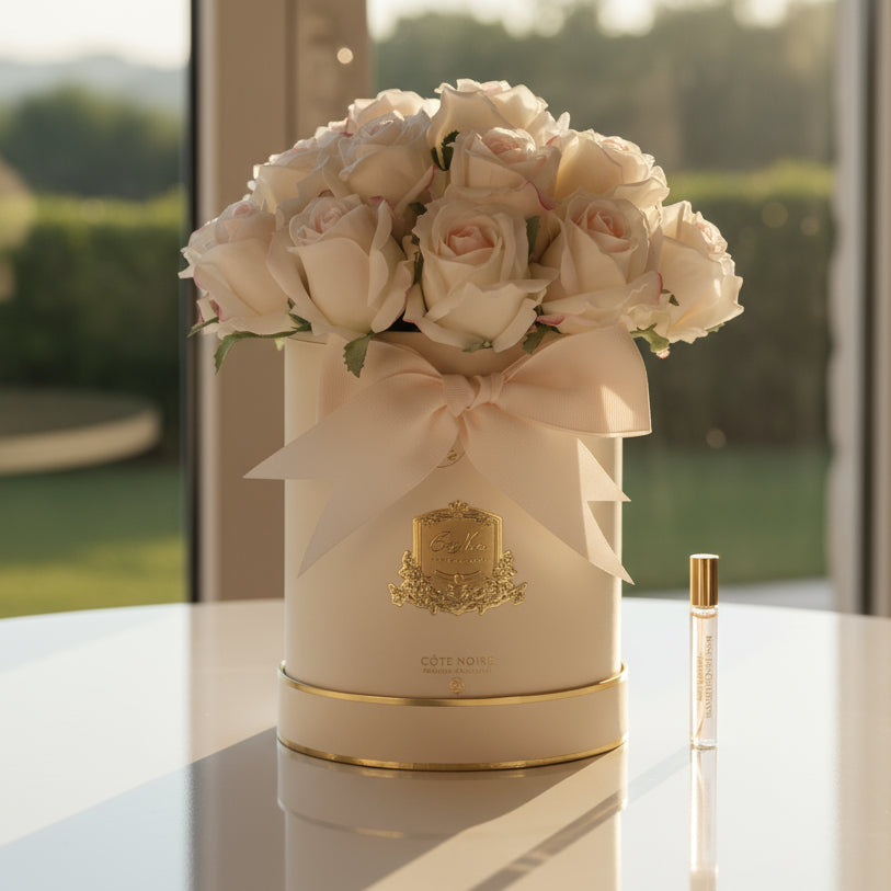 Floral cote noire rose bouquet in a decorative hat box with a perfume bottle for the diffuser flowers.