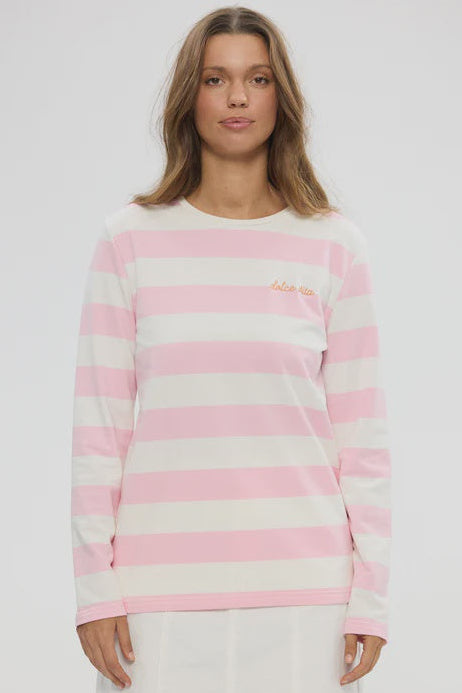 Woman wearing a pink and white striped sweater on a plain background