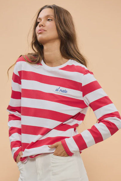 Woman wearing a red and white striped sweater with 'il more' text on a beige background