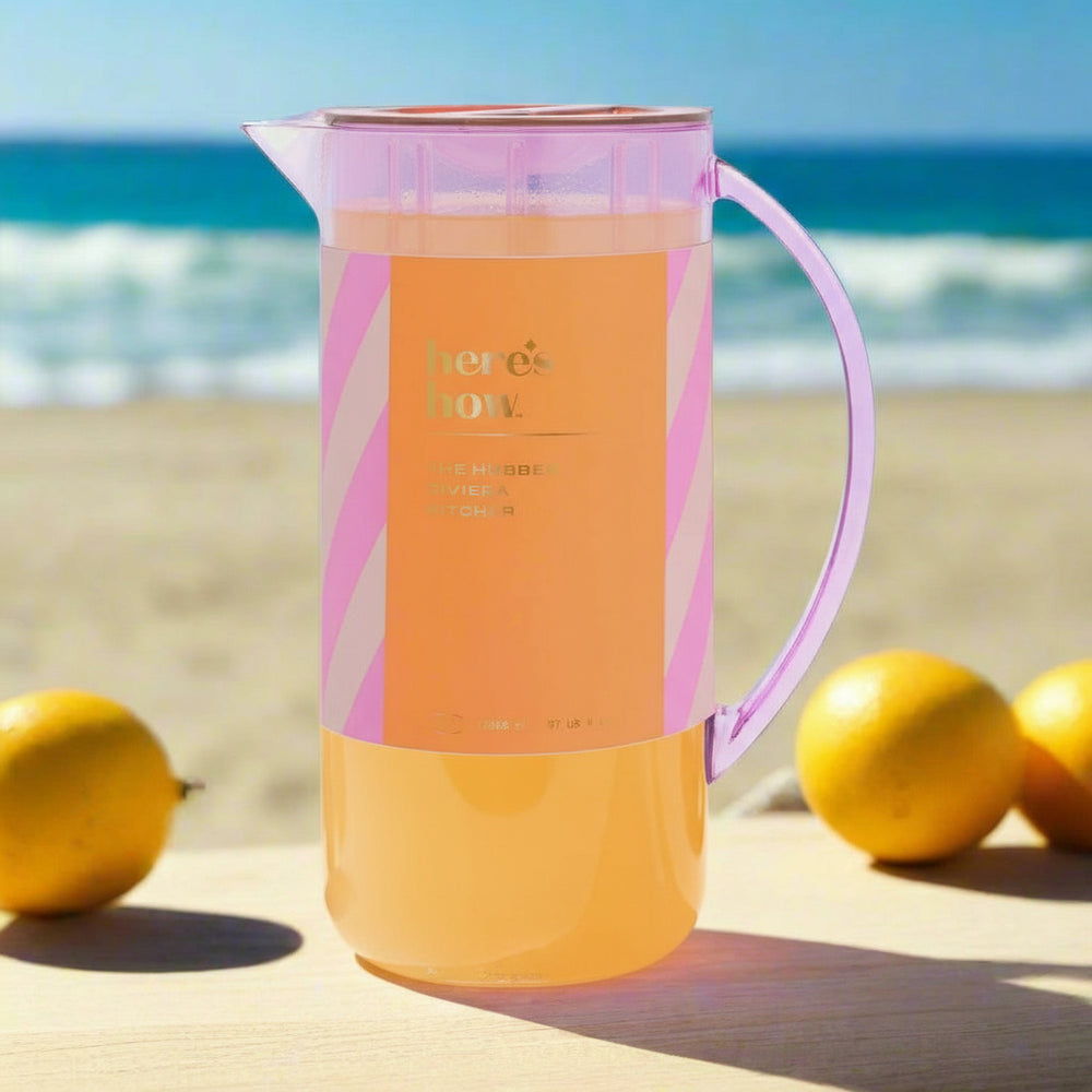 Pink and orange cocktail pitcher with 'here's how' text on a light gray background