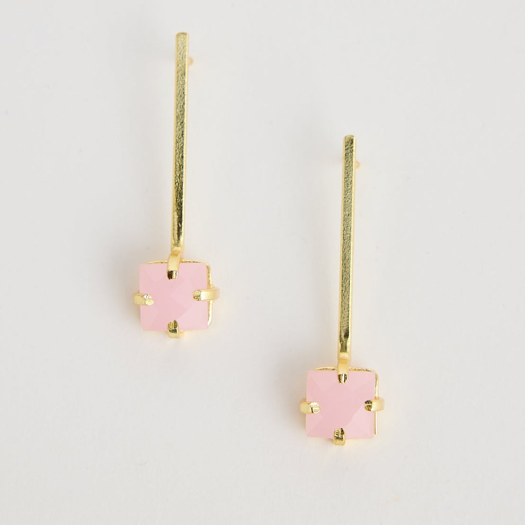 Pair of pink flower-shaped earrings on a light gray background