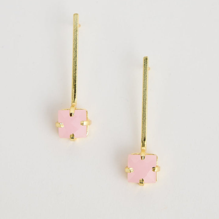 Pair of pink flower-shaped earrings on a light gray background