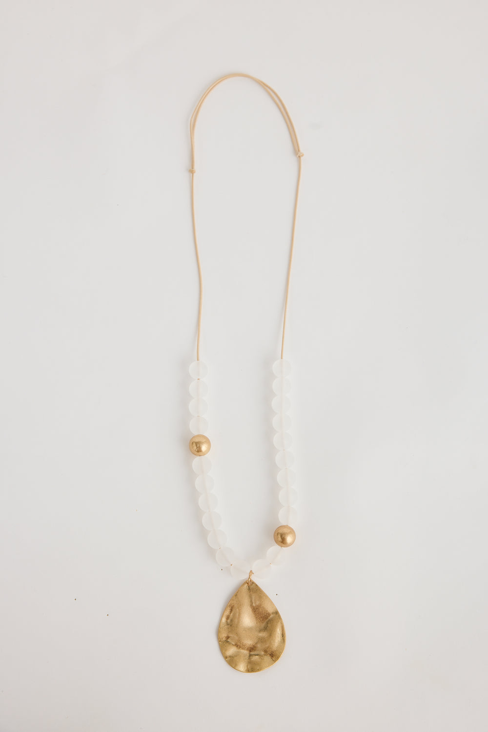 Necklace with a gold teardrop pendant on a white background