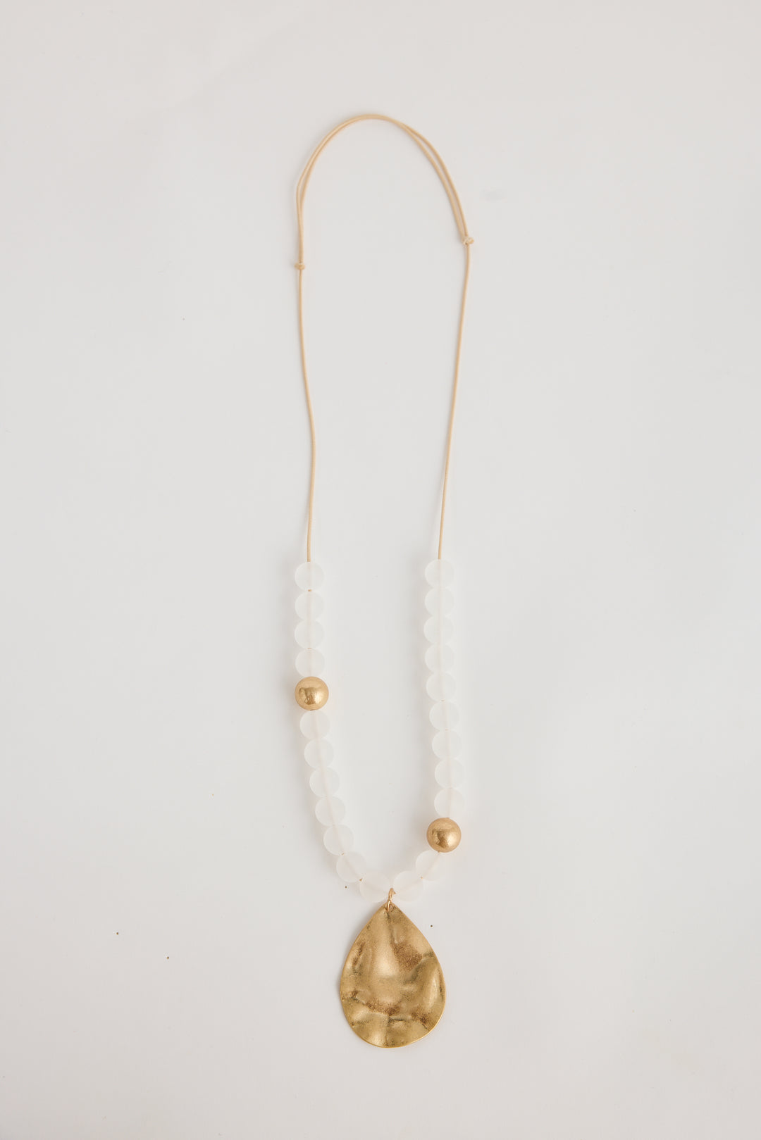 Necklace with a gold teardrop pendant on a white background