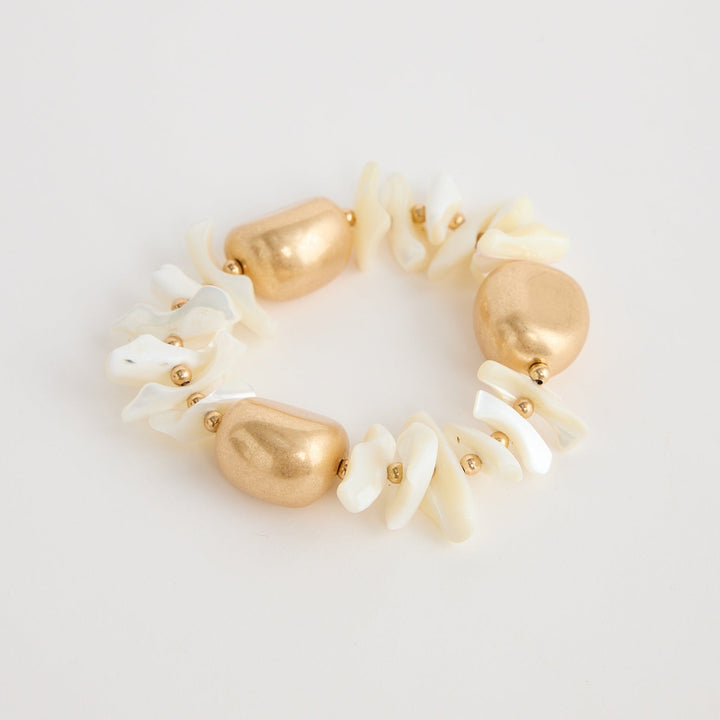 Gold and pearl hair tie on a light gray background
