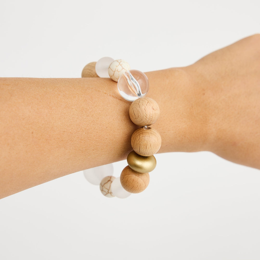 Wooden beaded bracelet on a wrist against a white background