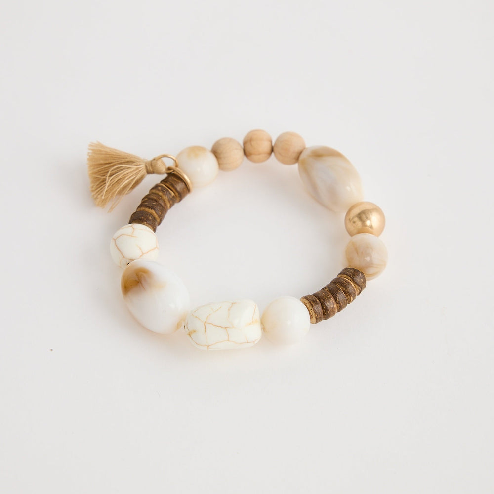 Beaded bracelet with tassel on a light gray background