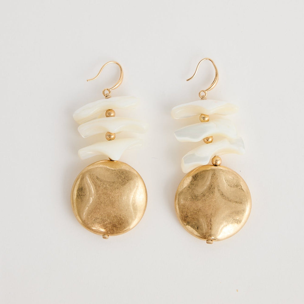 Pair of gold and white earrings on a light gray background