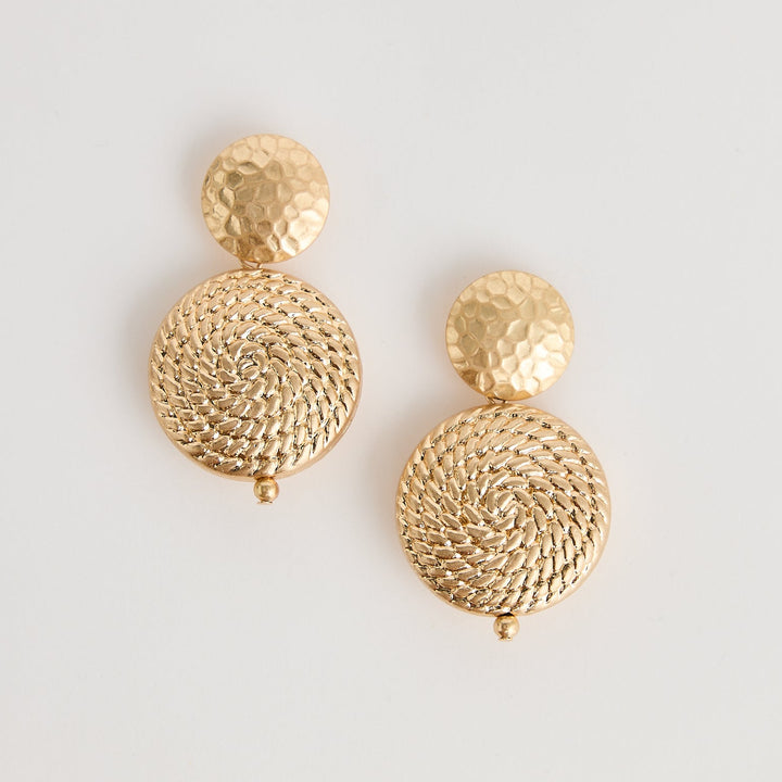 Gold earrings on a light gray background