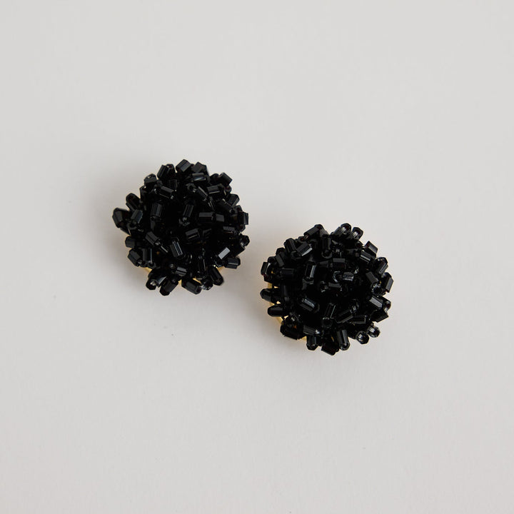 Pair of black stud earrings on a light gray background