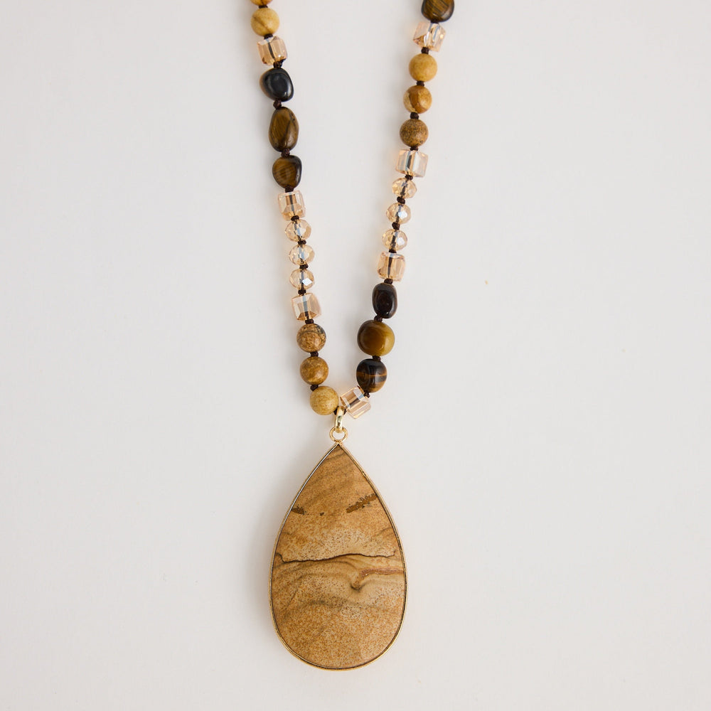 Beaded necklace with a wooden pendant on a light background