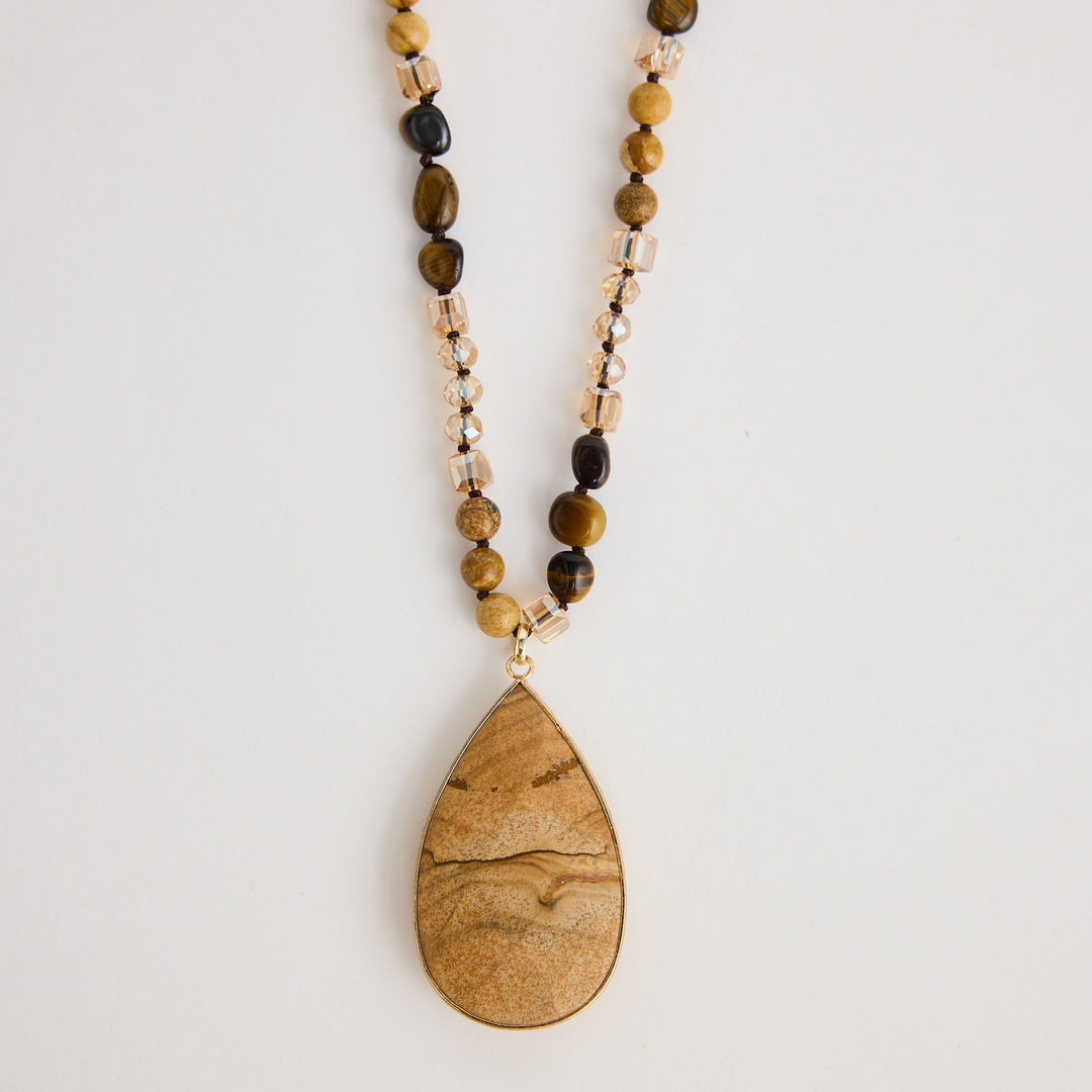 Beaded necklace with a wooden pendant on a light background