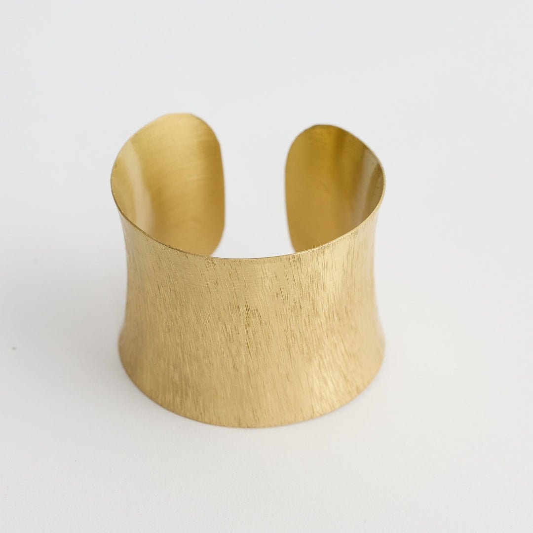 Gold cuff bracelet on a white background