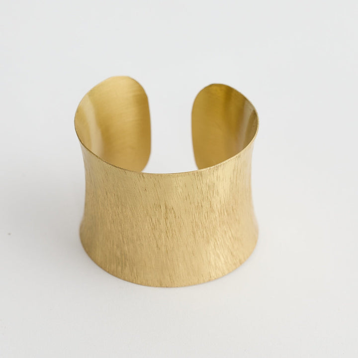 Gold cuff bracelet on a white background