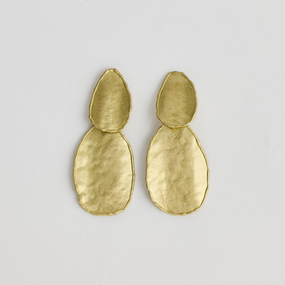 Pair of gold earrings on a light gray background