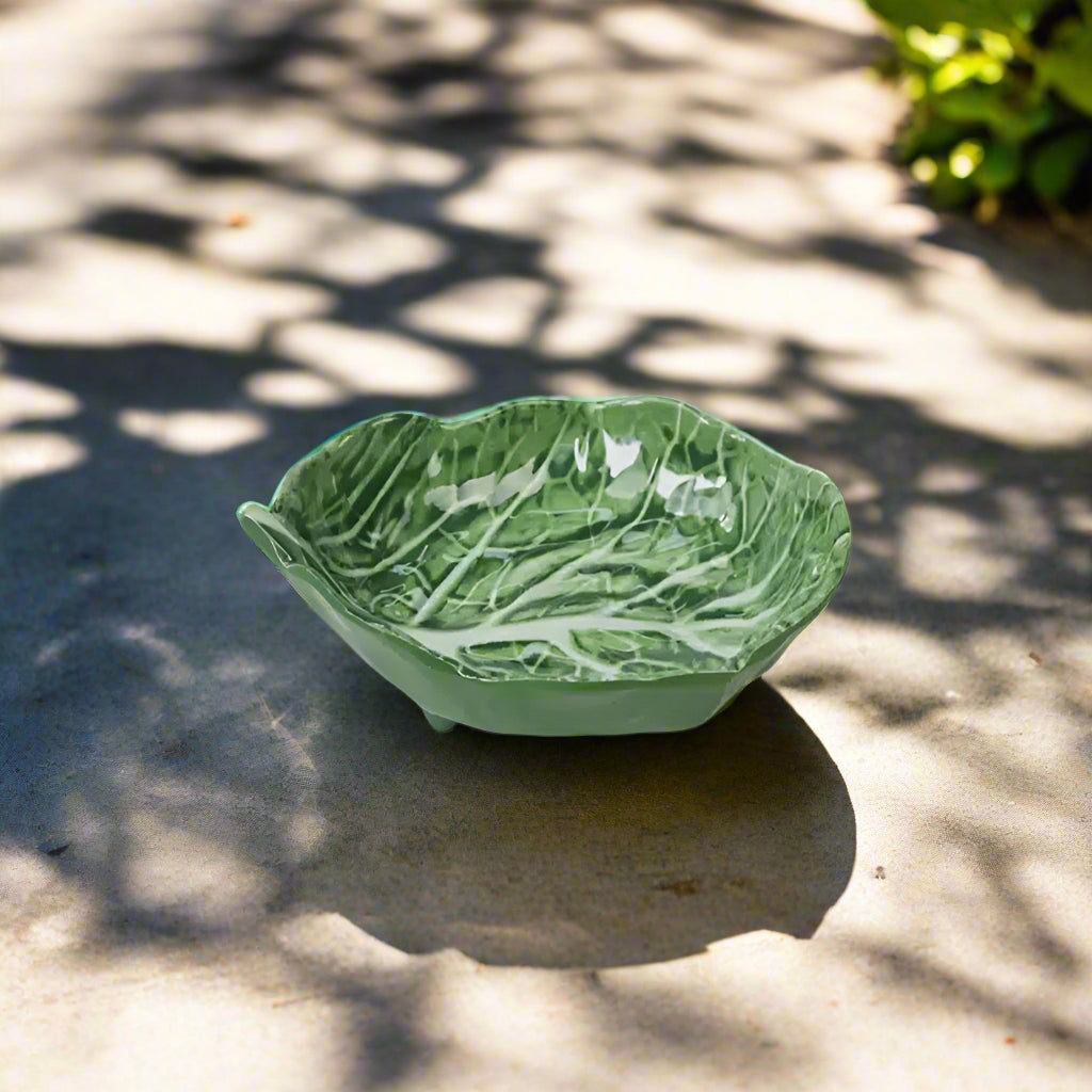 Green ceramic bowl with leaf pattern on a white background