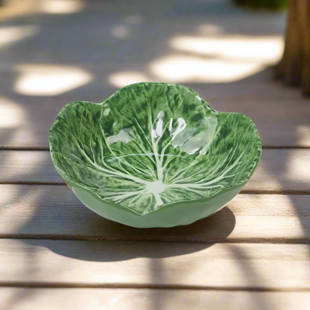 Green ceramic bowl with leaf pattern on a white background