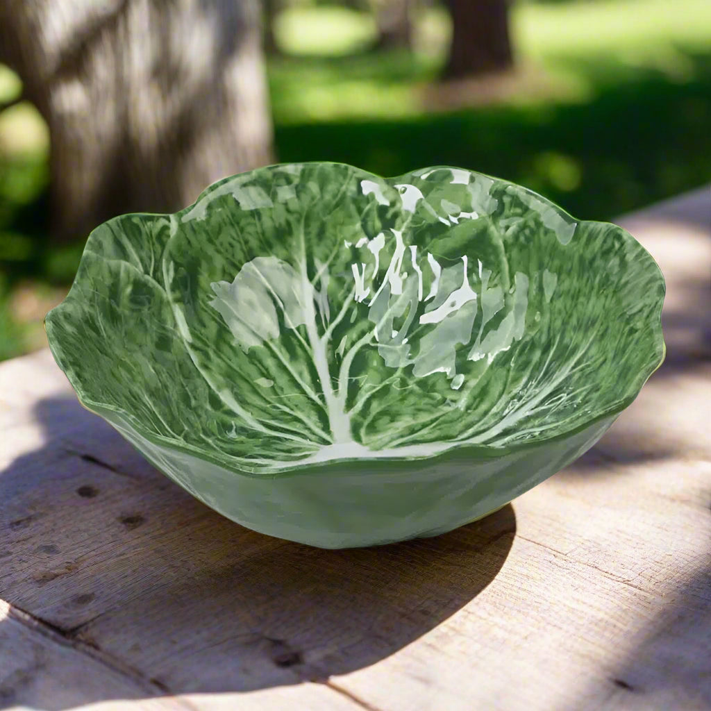 Green ceramic bowl shaped like a cabbage leaf on a white background