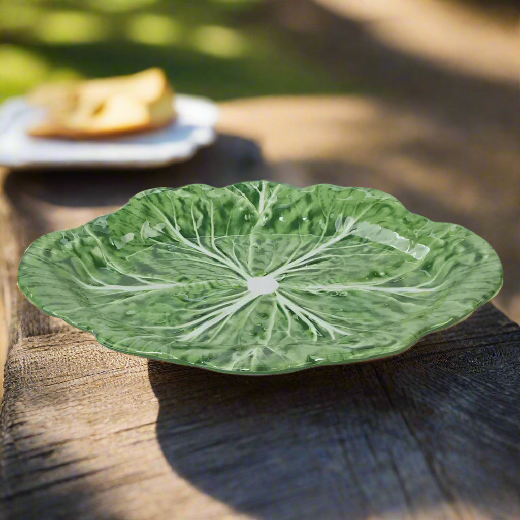 Green ceramic plate with leaf pattern on a white background