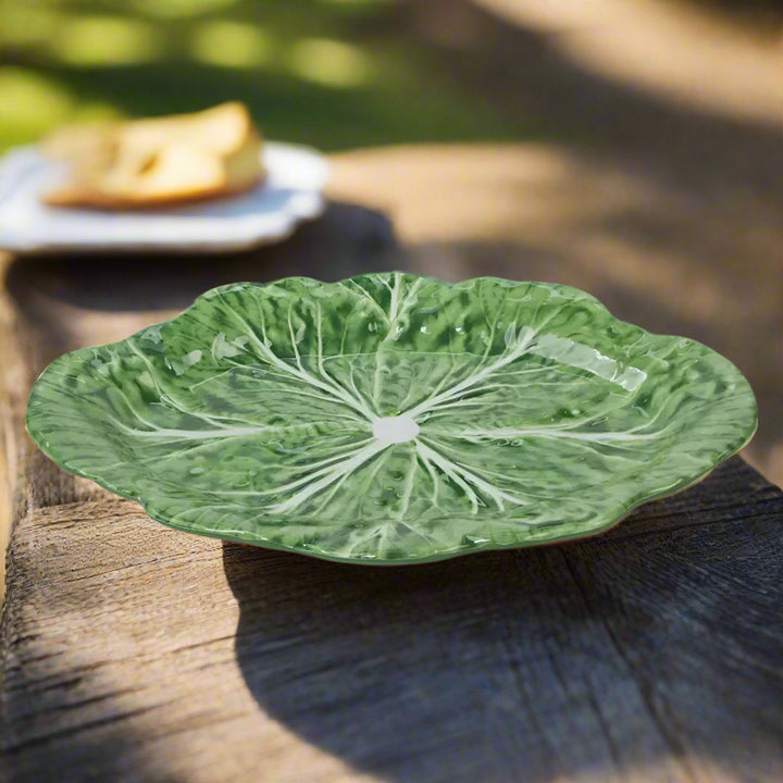 Green ceramic plate with leaf pattern on a white background