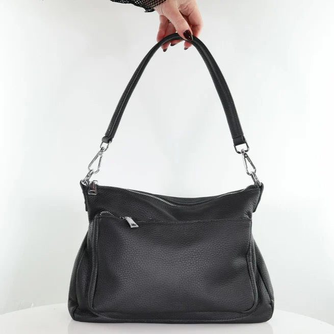 Black handbag held by a hand on a white background