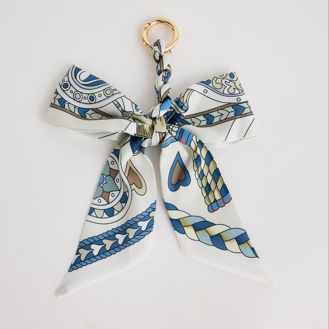 Decorative keychain with a patterned bow on a white background