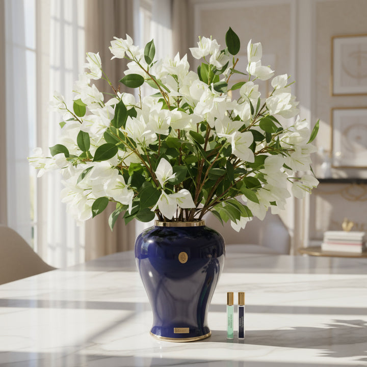 Navy blue vase with white cote noire diffuser bougainvillea flowers.