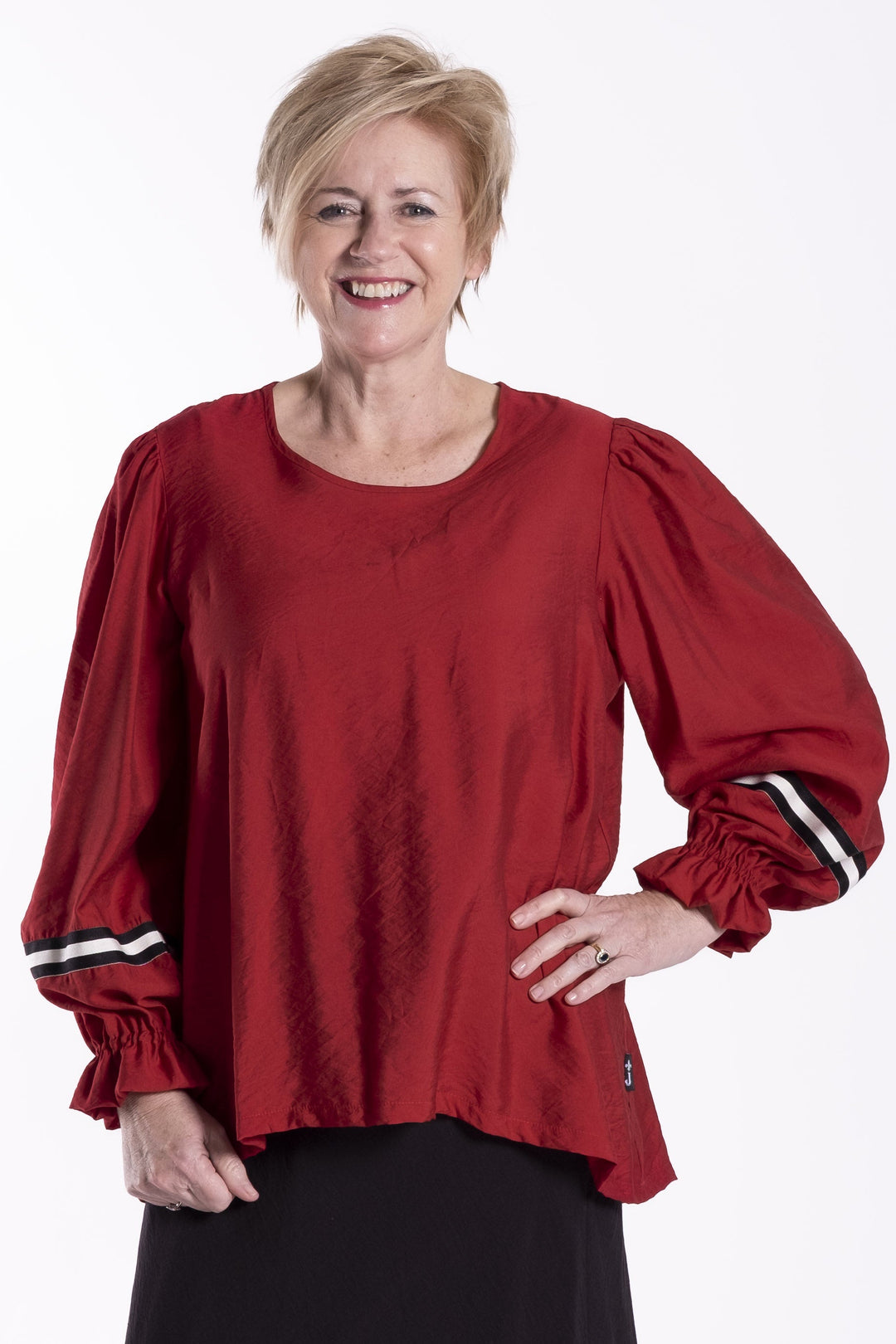 Person wearing a red jellicoe Claire  top and black skirt on a white background