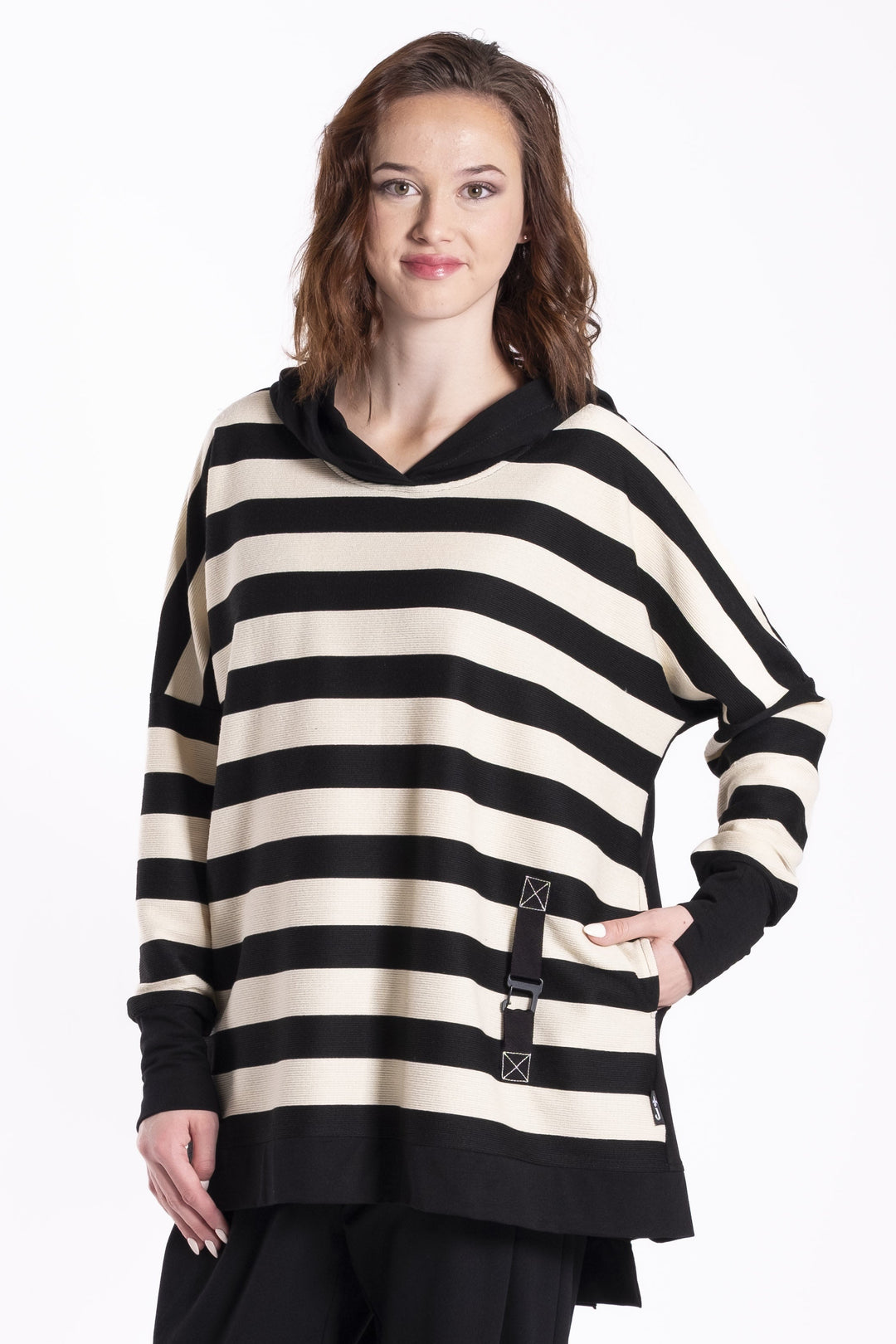 Woman wearing a black and white Jellicoe Latta striped sweater with a hood on a white background