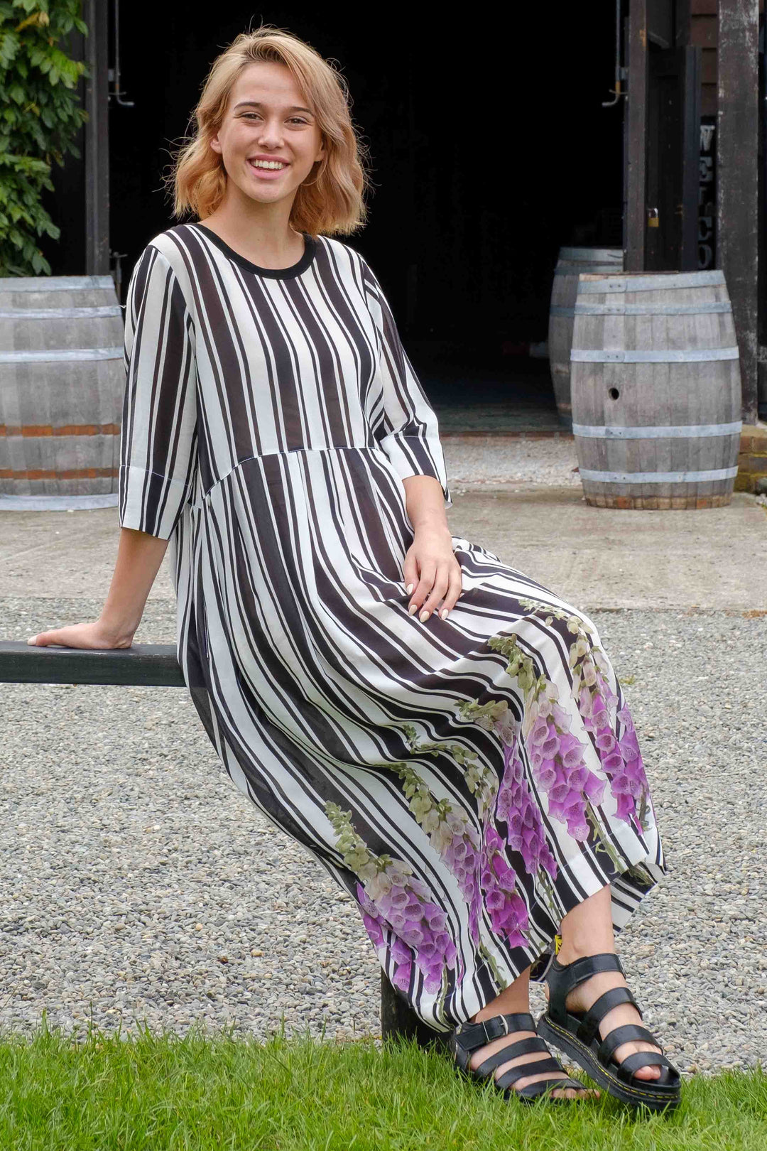 lady wearing a black & white striped foxgove aubrey dress by jellicoe in a rural country setting.