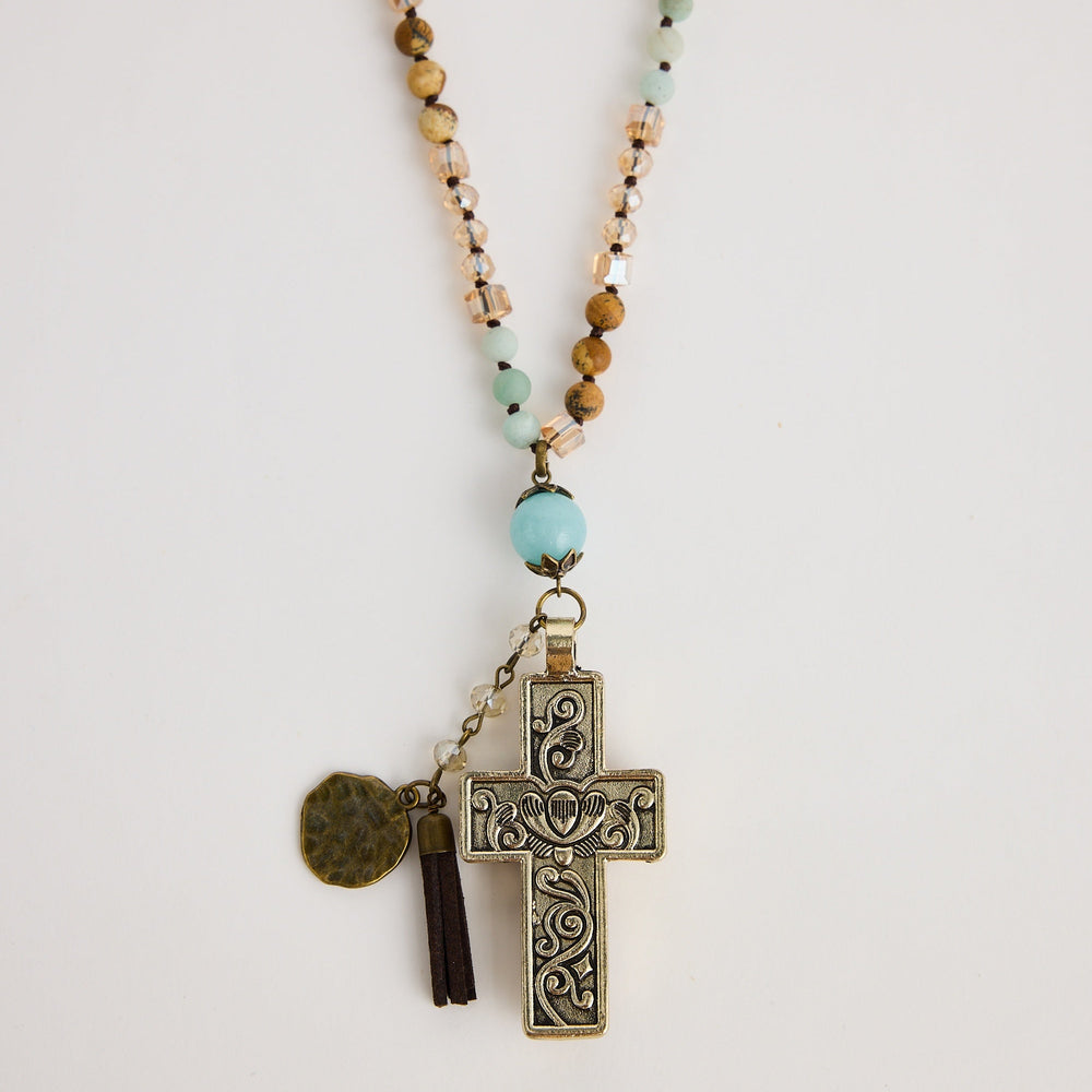 Necklace with beads and a cross pendant on a light background
