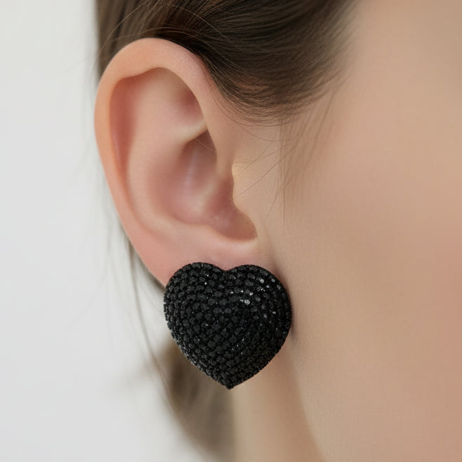Black heart-shaped earrings on a light gray background