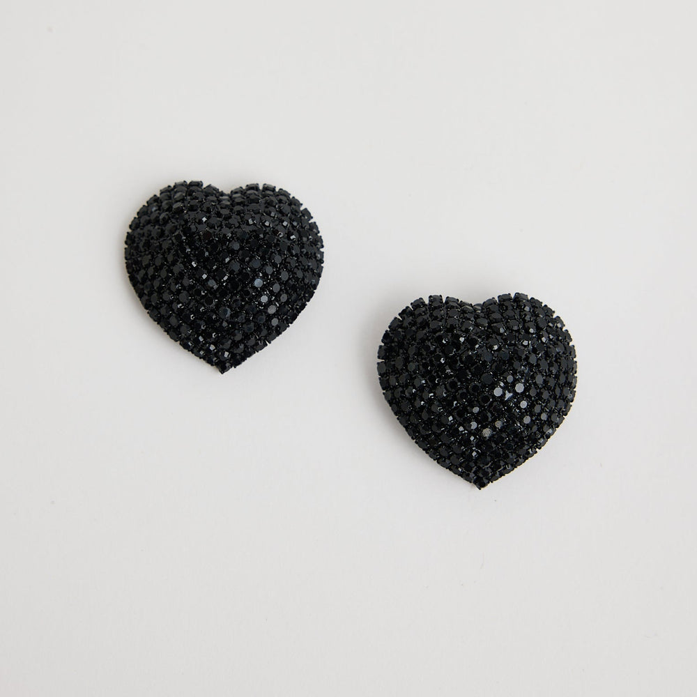Black heart-shaped earrings on a light gray background