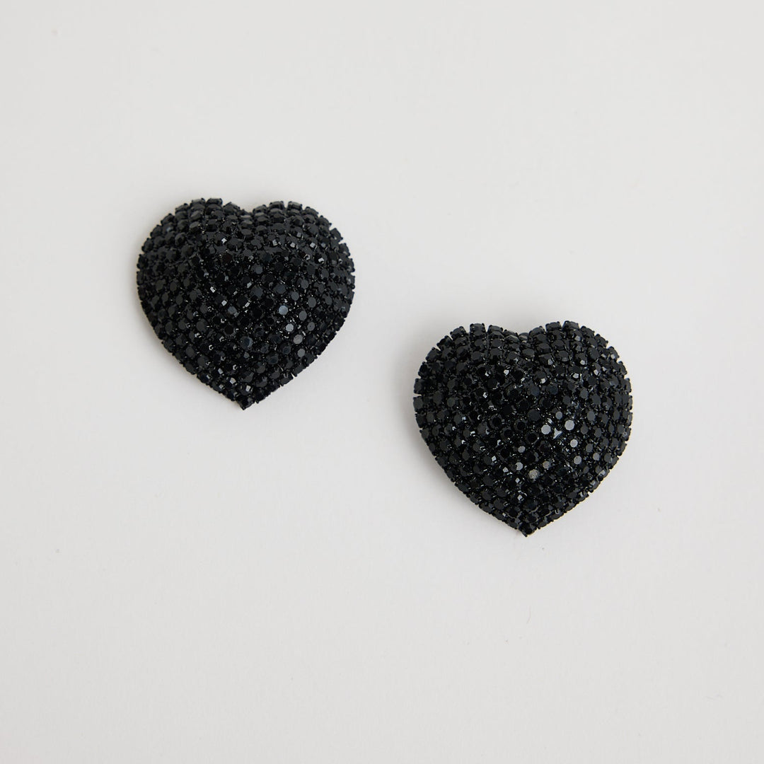 Black heart-shaped earrings on a light gray background