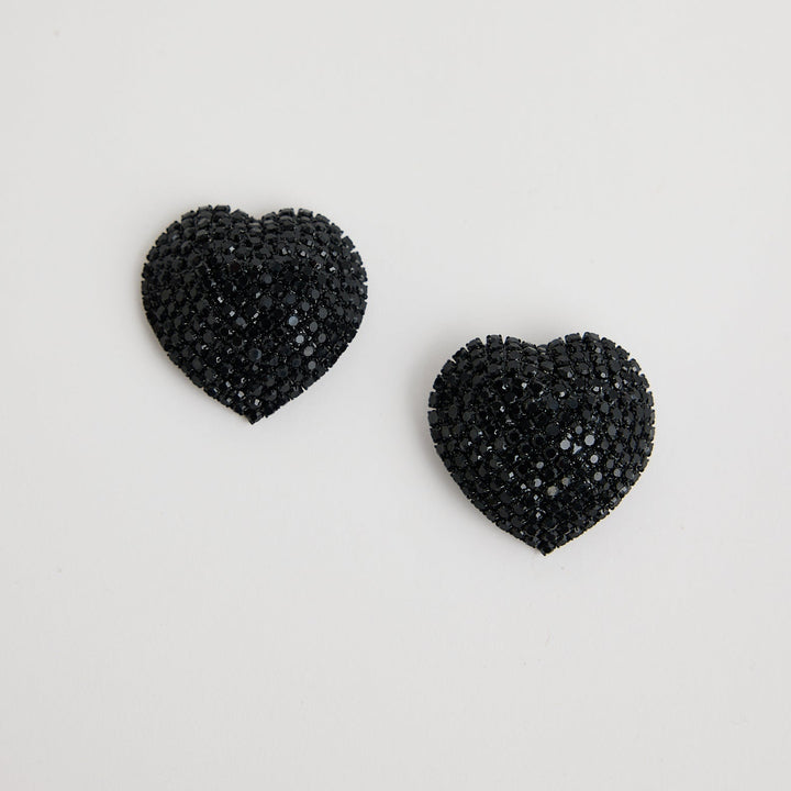 Black heart-shaped earrings on a light gray background