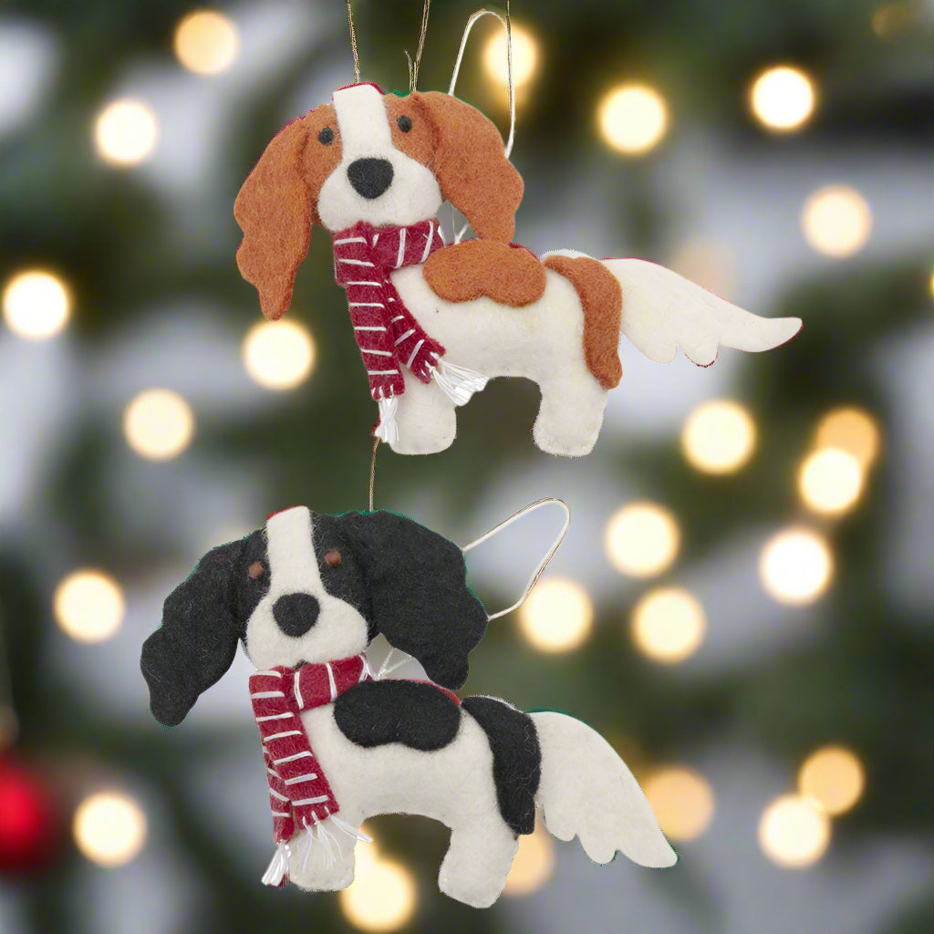 Two dog-shaped ornaments with scarves on a white background