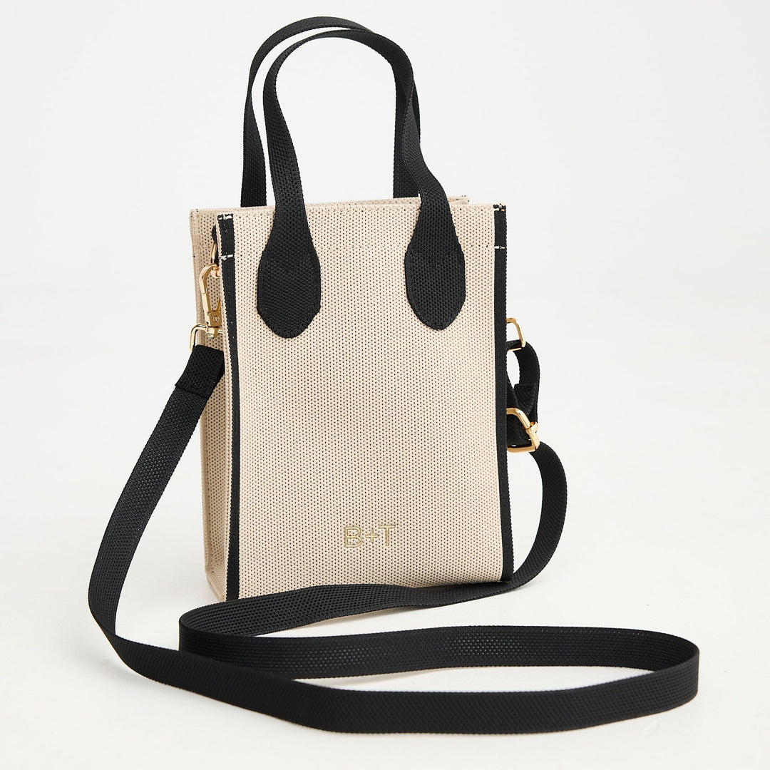 Beige handbag with black accents on a white background