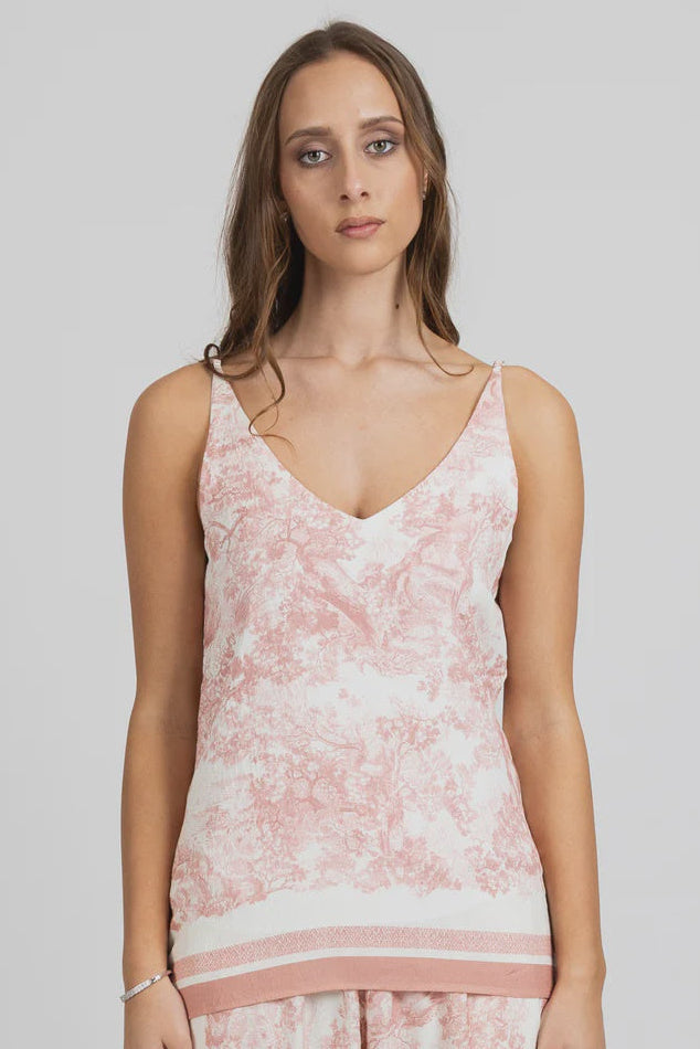 Woman wearing a pink floral federation twice singlet against a plain background